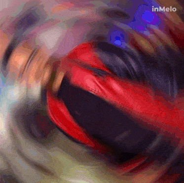 a blurry picture of a red and black object with inmelo written on the bottom right corner