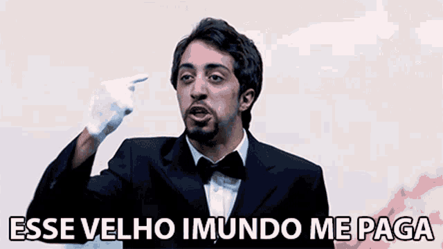 a man wearing a tuxedo and white gloves says " esse velho imudo me paga "