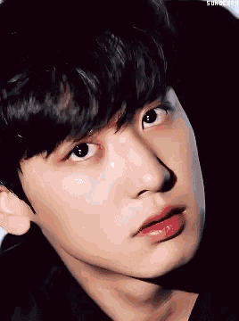 a close up of a young man 's face with a shadow on his face .