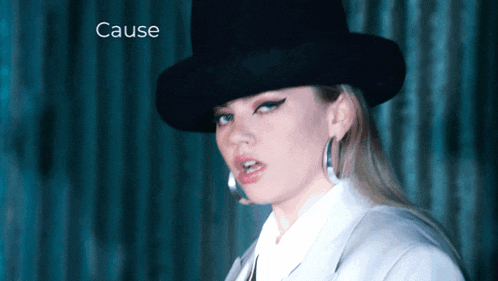 a woman wearing a black hat with the word cause written above her