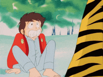 a boy in a red jacket sits on the ground