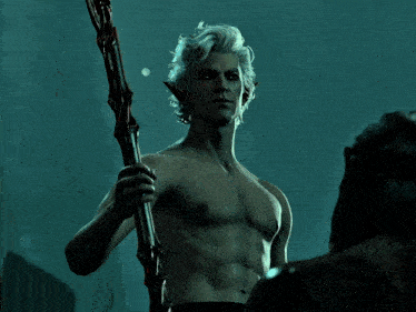 a man without a shirt is holding a sword and looking at another man
