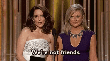 two women are standing next to each other on a stage and saying `` we 're not friends . ''