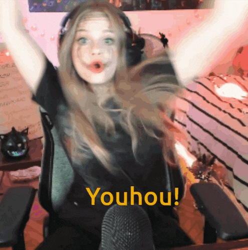 a girl is sitting in a chair with her arms in the air and the words youhou on the bottom right