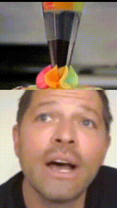 a close up of a man 's face with a rainbow colored flower on top of his head
