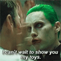 the joker from the movie suicide squad is talking to another man with green hair .