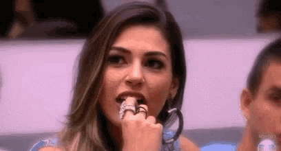 a woman with a ring on her finger is sitting in a room with a man .