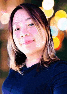 a woman 's face is shown with a blurred background of lights