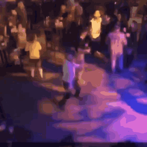 a blurry picture of a crowd of people dancing at a party