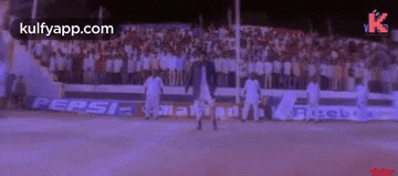 a man is dancing on a basketball court in front of a crowd of people .