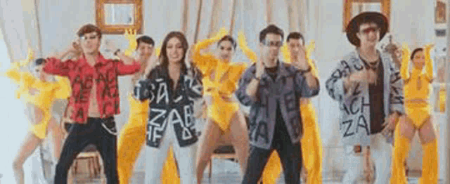 a group of people are standing next to each other in a room dancing .