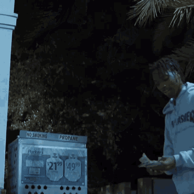 a man in a white hoodie holding a bunch of money