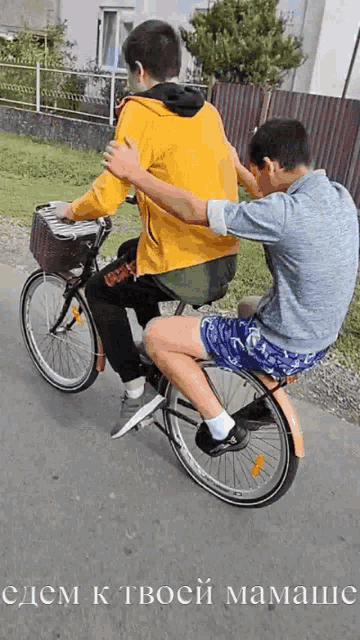 two boys are riding a bike with the words " cdem k tboc " on the bottom right