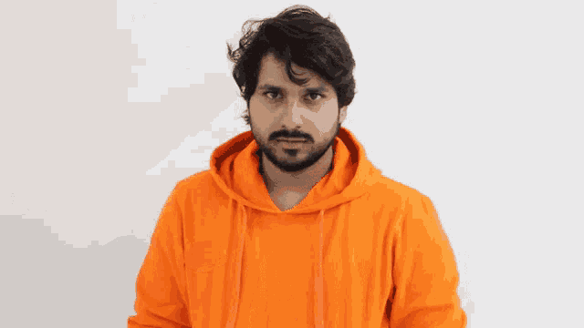 a man with a beard wearing a bright orange hoodie