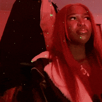 a woman with red hair is wearing a pink coat