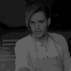 a black and white photo of a man wearing a white shirt and an apron .