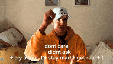 a man wearing an orange hoodie and a white adidas hat says dont care didnt ask cry about it stay mad get real l