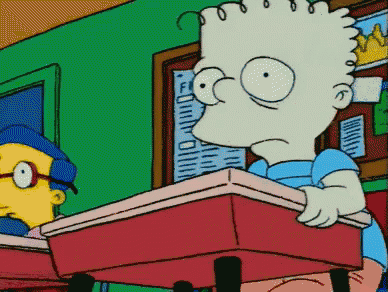 bart simpson is sitting at a desk in a classroom looking at something