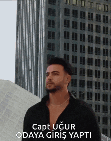 a man in a black shirt is standing in front of a tall building