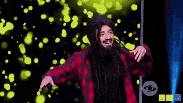 a man with long hair and a beard is dancing on stage