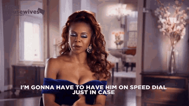 a woman in a blue off the shoulder dress says " i 'm gonna have to have him on speed dial just in case "