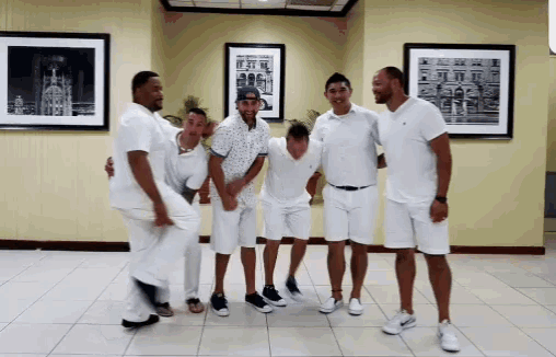 a group of men wearing white shirts and shorts are posing for a picture