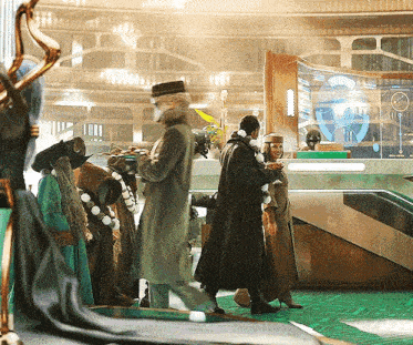 a group of people are standing in a room with a green floor