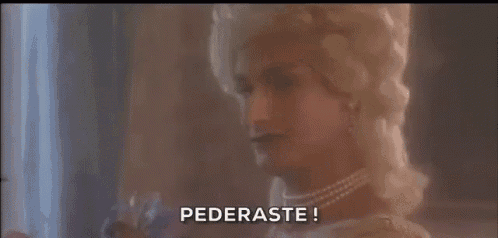a woman in a white wig and pearls says pederaste !