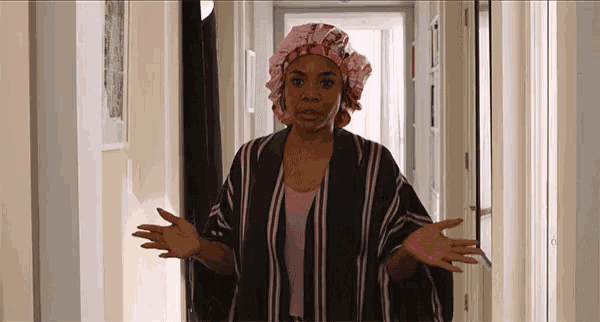 a woman wearing a shower cap is standing in a hallway with her hands outstretched