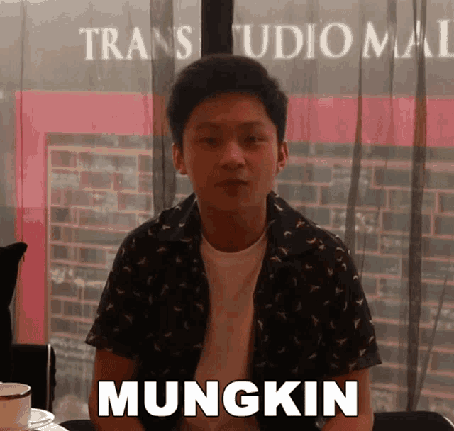 a young man sitting in front of a trans studio mall says mungkin