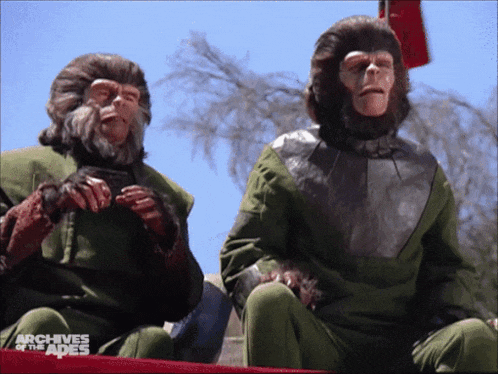 two monkeys are sitting on a red table with the words archives of the apes on the bottom right