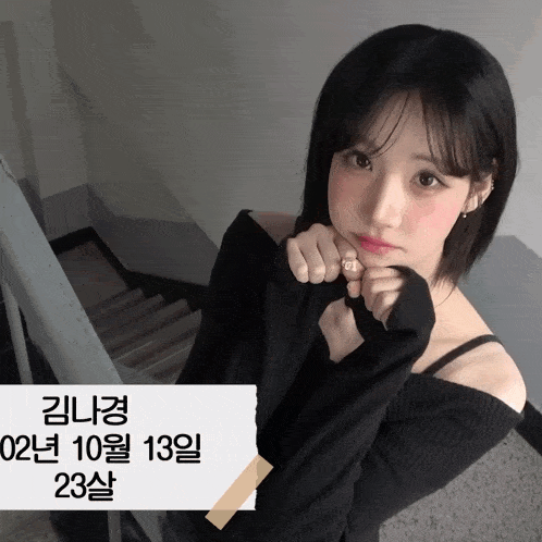 a girl in a black off the shoulder top is standing in front of a staircase