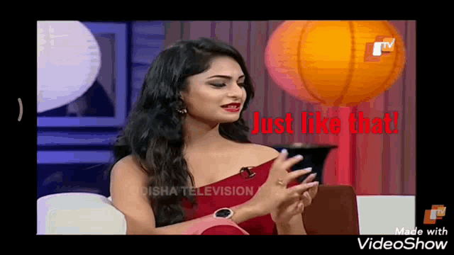 a woman in a red dress is sitting on a couch with the words just like that written in red