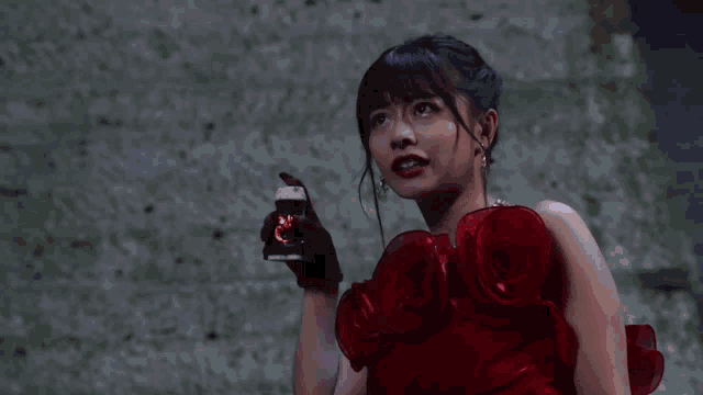 a woman in a red dress is standing in front of a wall