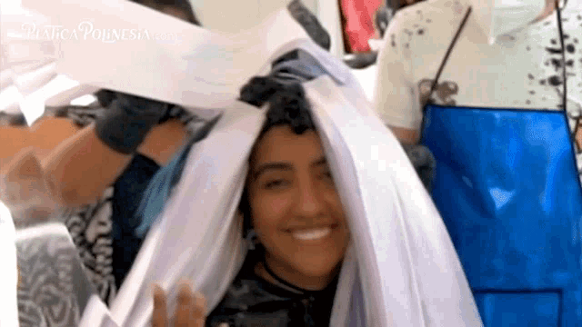 a woman is smiling while being wrapped in a white cloth and the website plastic pounesia.com is visible behind her