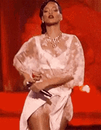 a woman in a white dress is holding a microphone and dancing