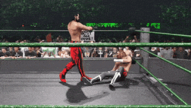 two wrestlers in a ring with one holding a sign that says " best guys here "