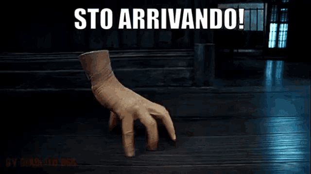 a hand with a glove on it is reaching out towards the camera with the words sto arrivando below it