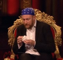 a man wearing a blue bandana is sitting on a throne