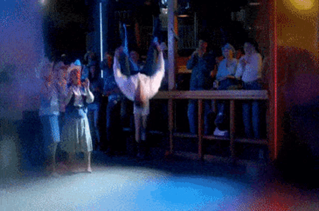 a man is doing a handstand on a stage in front of a crowd