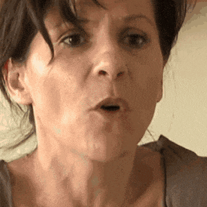 a close up of a woman making a funny face with her mouth open .