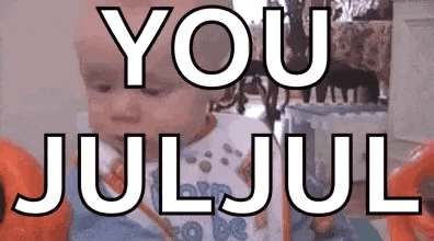 a baby is sitting in a chair with the words `` you juljul '' written on it .