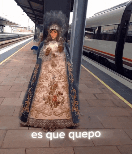 a statue of a woman is standing in front of a train with the words " es que quepo " below it