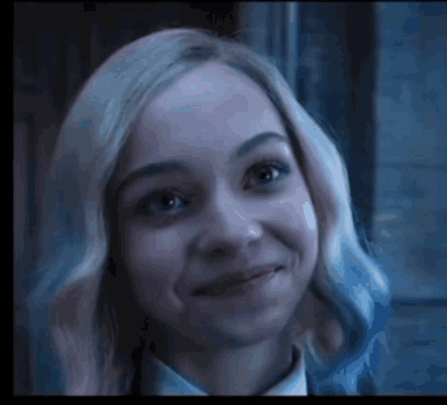 a close up of a woman with blonde and blue hair smiling