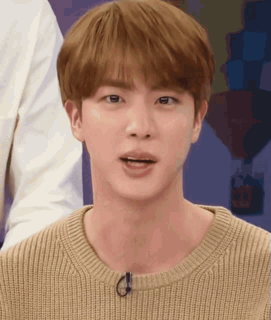 a close up of a person wearing a sweater with a microphone