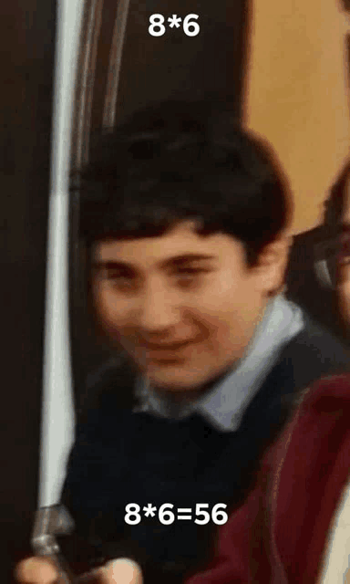 a young boy is smiling and holding a cell phone with the number 8 written on it