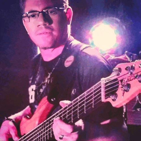 a man wearing glasses is playing a guitar with the number 16 on his shirt