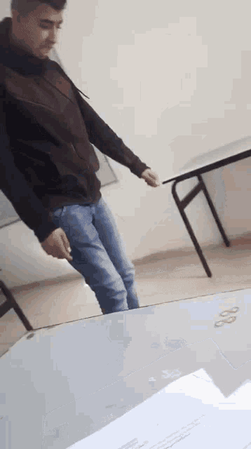 a man is standing in front of a table with a piece of paper that says 88 on it