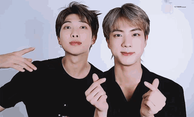 two young men making a heart shape with their fingers