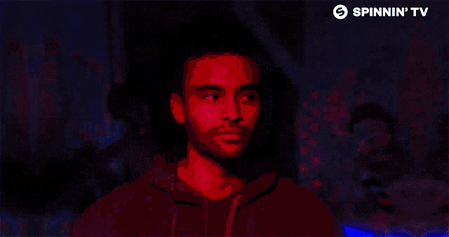 a man is standing in front of a sign that says spinnin 'tv